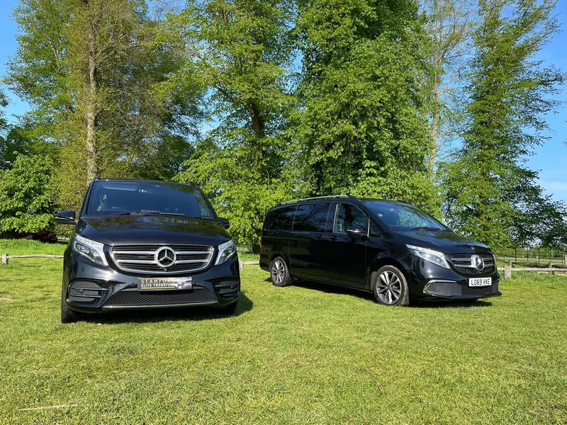 Two black Mercedes V Class vehicles parked on grass